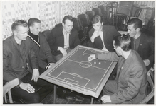 M 8625 Theorieavond S.C.E. te Zoelen (voetbalclub), zes jonge mannen bij een tafel met afbeelding voetbalveld, 1 ...