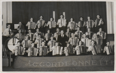 M 8795 Waarschijnlijk uitvoering accordeonorkest Accordeonnette . In het midden dirigent dhr. Van Meteren