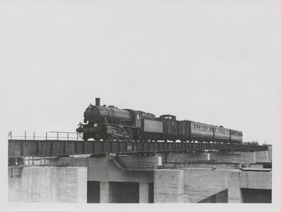 884 Het treinviaduct van de Prins Bernhardsluis waarover een oude locomotief rijdt in de richting van Kesteren