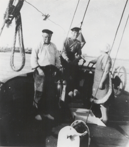 M 9167 Twee mannen en een vrouw op een schip op ws. de Waal, jongste man aan het roer.