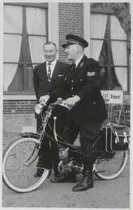 M 9206 Politieman op fiets voor een café, in gesprek met man naast hem