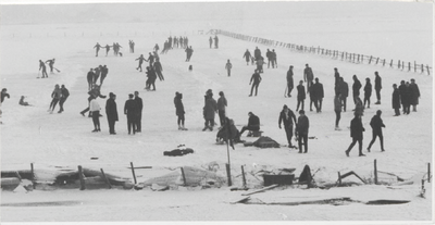 M 9333 Groep mensen op het ijs, waarschijnlijk op uiterwaard, velen zijn aan het schaatsen.