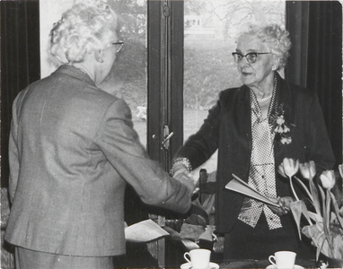 M 9400 Viering jubileum UVV, twee oudere dames schudden elkaar de hand
