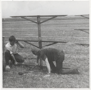 M 9410 Twee mannen repareren een hek in weiland