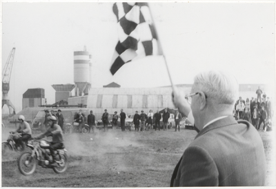 M 9457 Startsein motorcross Wethouder G. van Uitert op bedrijfsterrein Kellen. Op de achtergrond de Fa. Betuwe Beton