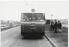M 9481 Bushalte Nieuwe Tielseweg, bus van BSM Tiel stopt bij halte, drietal personen staat bij de halte