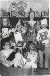 M 9641 Kinderboekenweek in Bibliotheek, aantal kinderen verkleed met boeken in de handen