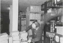 0690-2416 Dhr. W. Veerman bezig met de archiefstukken stof vrij te maken in de kluis van het archief op Achterbonenburg.