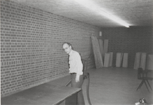 0690-2427 Dhr. Veerman bezig met stofzuigen voor het plaatsen van rolkasten in de kluis van het archief op Achterbonenburg.