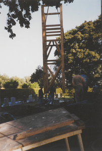 0690-3872 Het op hijsen van het geraamte van het torentje tijdens de restauratie van de kerk.