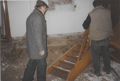 0690-3898 Ds. F. Scheffel kijkt toe hoe zijn trap naar de preekstoel wordt verwijdert, bij de restauratie van de kerk.