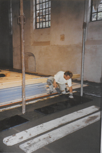 0690-3959 Tegelzetter bij het aanbrengen van de vloertegels in de kerk.