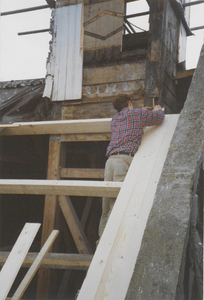 0690-3963 Timmerman bezig met nieuw dakbeschot tijdens de restauratie van de kerk.