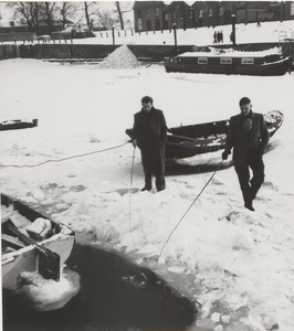 105 Twee vissers op de bevroren haven. Op de achtergrond de huizen aan de Veerweg.