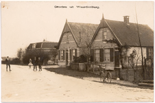 1096 Een prentbriefkaart van een straat in Waardenburg met drie huizen met nokversiering