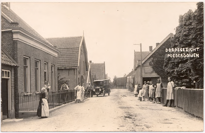 1156 Een prentbriefkaart van de Maasdijk in Poederoijen met poserende bewoners en een auto. Links de bakkerij van Piet ...
