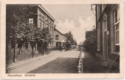 1168 Een prentbriefkaart van de Nieuwstraat in Kerkdriel met enkele poserende dorpsbewoners