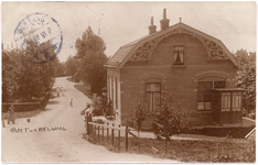 1188 Een prentbriefkaart van de Kerkstraat in Nieuwaal gezien vanaf de Waalbandijk, met rechts een huis met een fraaie ...