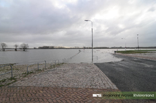 975 Foto van het hoogwater aan de Waalkade in Tiel. De gemeente Tiel heeft het parkeerterrein op de kade afgesloten ...