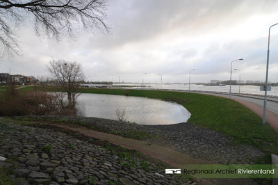 981 Foto van het hoogwater aan de Waalkade in Tiel. De gemeente Tiel heeft het parkeerterrein op de kade afgesloten ...
