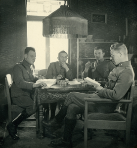 1080 Mobilisatie Kesteren en omgeving: 4 militairen lezend en rokend aan een tafel in een woonkamer