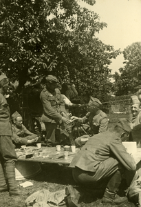 1116 Mobilisatie Kesteren en omgeving : groep van 6 militairen eten en drinken buiten aan een tafel