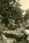 Mobilisatie Kesteren en omgeving : groep van 6 militairen eten en drinken buiten aan een tafel