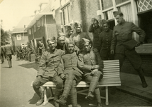 Mobilisatie Kesteren en omgeving : groep militairen zittend op en staand bij een bank voor een rij woonhuizen