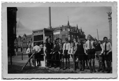 4-1012 Een aantal jongens rondom een telefooncel tijdens een schoolreisje naar 's Hertogenbosch om hun te leren ...