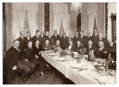 4-632 22 leden van de Kamer van Koophandel voor de Neder-Betuwe, zittend en staand aan een mooi gedekte tafel vanwege ...