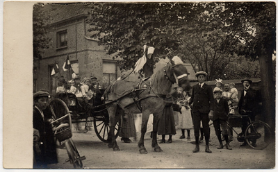 4-667 Vrolijk versierde kar met paard, daarop een aantal kinderen, rijdend door de straat met langs de kant wat ...