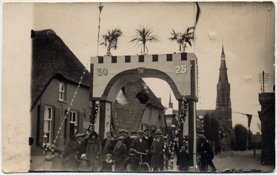 4-741 Een aantal mensen staande onder de ereboog die gemaakt is ter gelegenheid van het Gouden Priesterfeest van ...