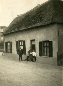 4-795 Familie M. de Raad - van Tiel met hun twee kinderen staande buiten voor hun huis.