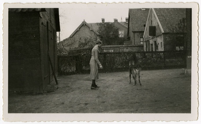 4-796 Drika van Doornmalen met hond voor haar huis, de huizen op de achtergrond zijn de garage van Jan van Doornmalen ...