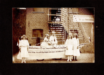 4-896 Vier meisjes en een als matroos uitziende man voor een nagemaakt bootje staand voor de mandenfabriek van M. van ...