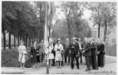 9-71 Groep personen gaat de vlag hijsen ter gelegenheid van de opening van het hertenkamp. De burgermeester (man met ...