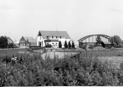 10-15016 Maasdijk gezien vanaf de Molendijk. Het witte huis is het veerhuis. Op de achtergrond de verkeersbrug over de Maas.