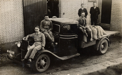 16-186 Vijf mannen van de Coöperatie op en achter een vrachtwagen waarop enkele zakken staan. Vlnr: 1. Wim van Loon ...