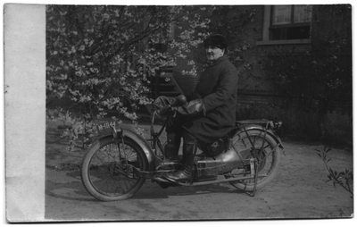 21-240 Dominee A.A. van Stipriaan Luïscuis op de motor in de tuin voor een huis.