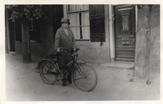 21-269 Vroedvrouw F. Rooker met fiets voor haar huis.