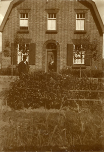 21-313 Twee personen buiten voor een huis. Vlnr: 1. Bert van Genderen, 2. Marie van Duijnen (van Genderen).