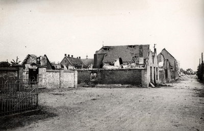 14-1483 Door oorlog verwoeste woningen, zicht richting Kerkstraat. Links de ommuurde speelplaats van de lagere school, ...