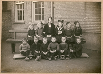 22-8153 Schoolfoto: openbare lagere school II, 1e klas. Van links naar rechts op de bank: Lies Berkhout, Nelly van ...