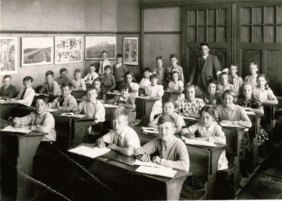 22-8164 Schoolfoto: christelijke lagere school, 4e klas meester Griffioen. Schoolbanken rij op de voorgrond, van rechts ...