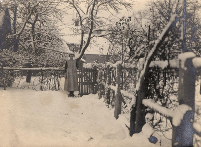 21-441 Vrouw in de sneeuw bij hek