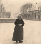21-445 Onbekende oude vrouw, met muts/kapje, in de sneeuw bij het kruispunt Heust - Dijkstraat