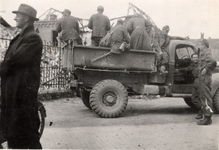 4-2311 Duitse krijgsgevangen in de laadbak van een truck van de geallieerden kijken naar de puinhopen van de katholieke ...
