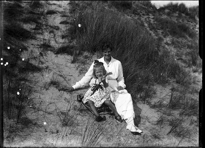 22-9569 Vrouw met een kind zittend in de duinen