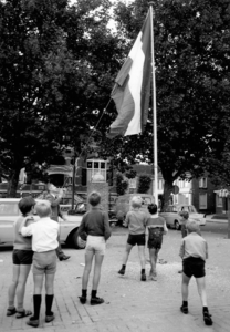 14-294 Onder het toeziend oog van zeven jongens hijst burg. Van Gils de vlag op het Mgr. Zwijsenplein ter ere van?