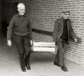 14-353 Twee bewoners van bejaardenhuis De Leijenstein lopen met een kist aardappels door de gang naar de keuken. Links ...